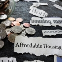 Photo of change and newspaper clippings saying affordable housing crisis