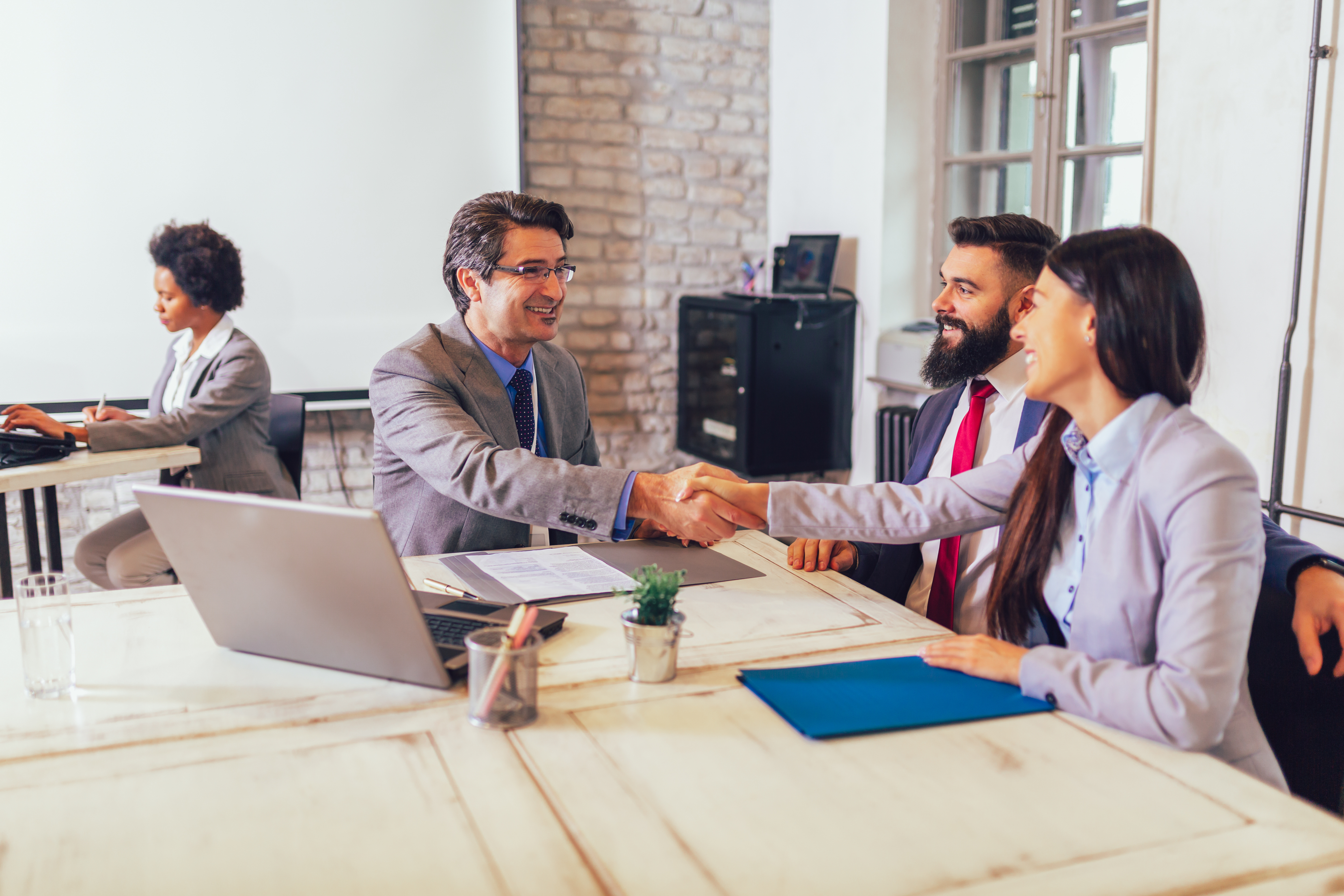 Banker shaking hands with two people
