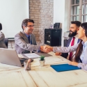Banker shaking hands with two people
