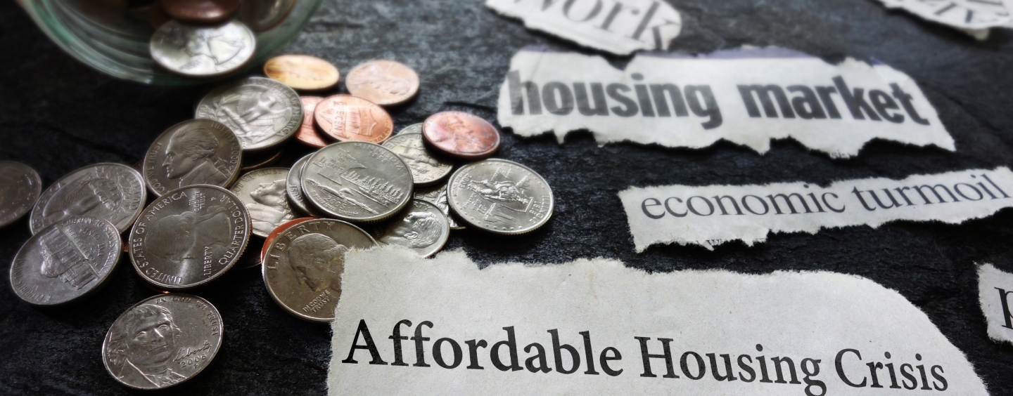 Photo of change and newspaper clippings saying affordable housing crisis