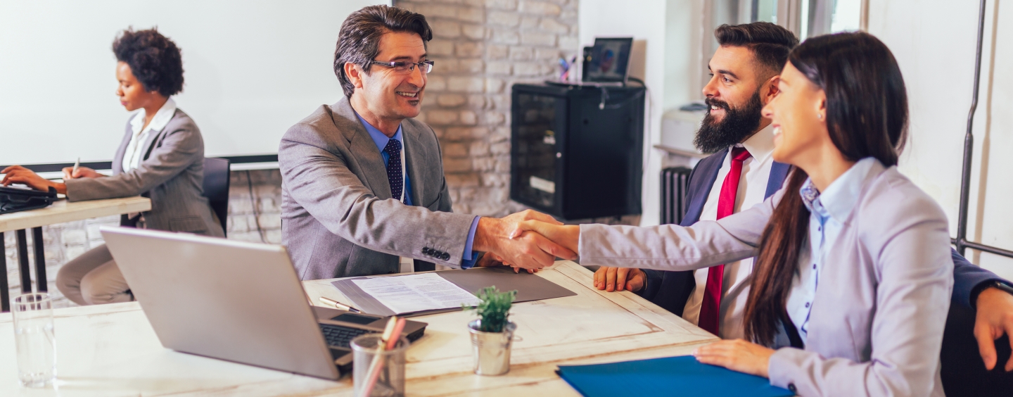 Banker shaking hands with two people