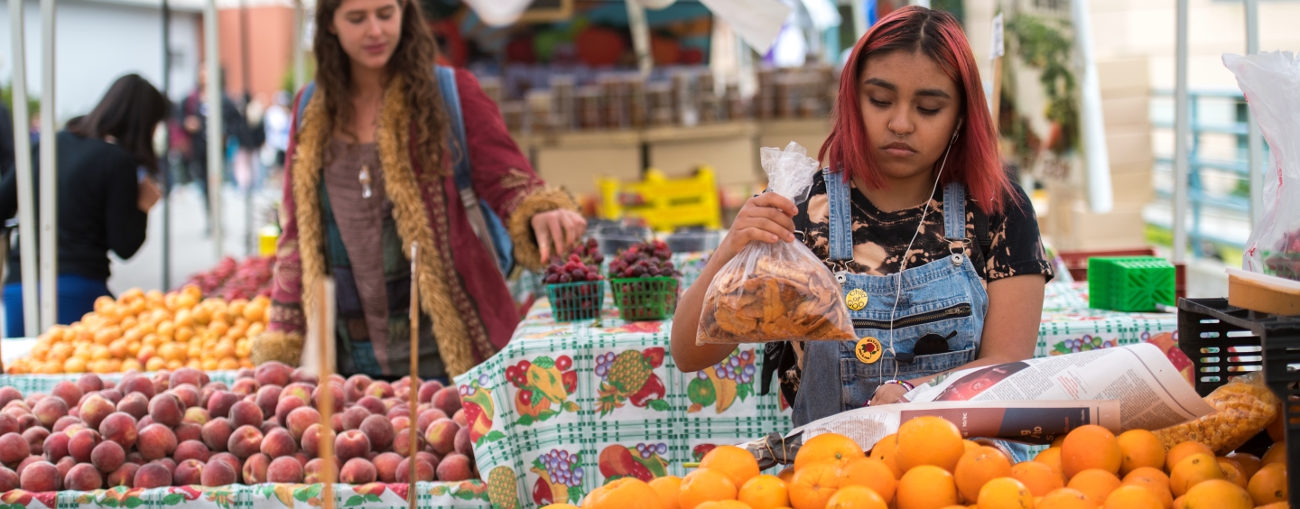 Two individuals being produce at the farmers' market