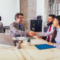 Banker shaking hands with two people