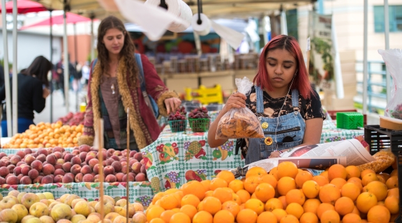 Two individuals being produce at the farmers' market